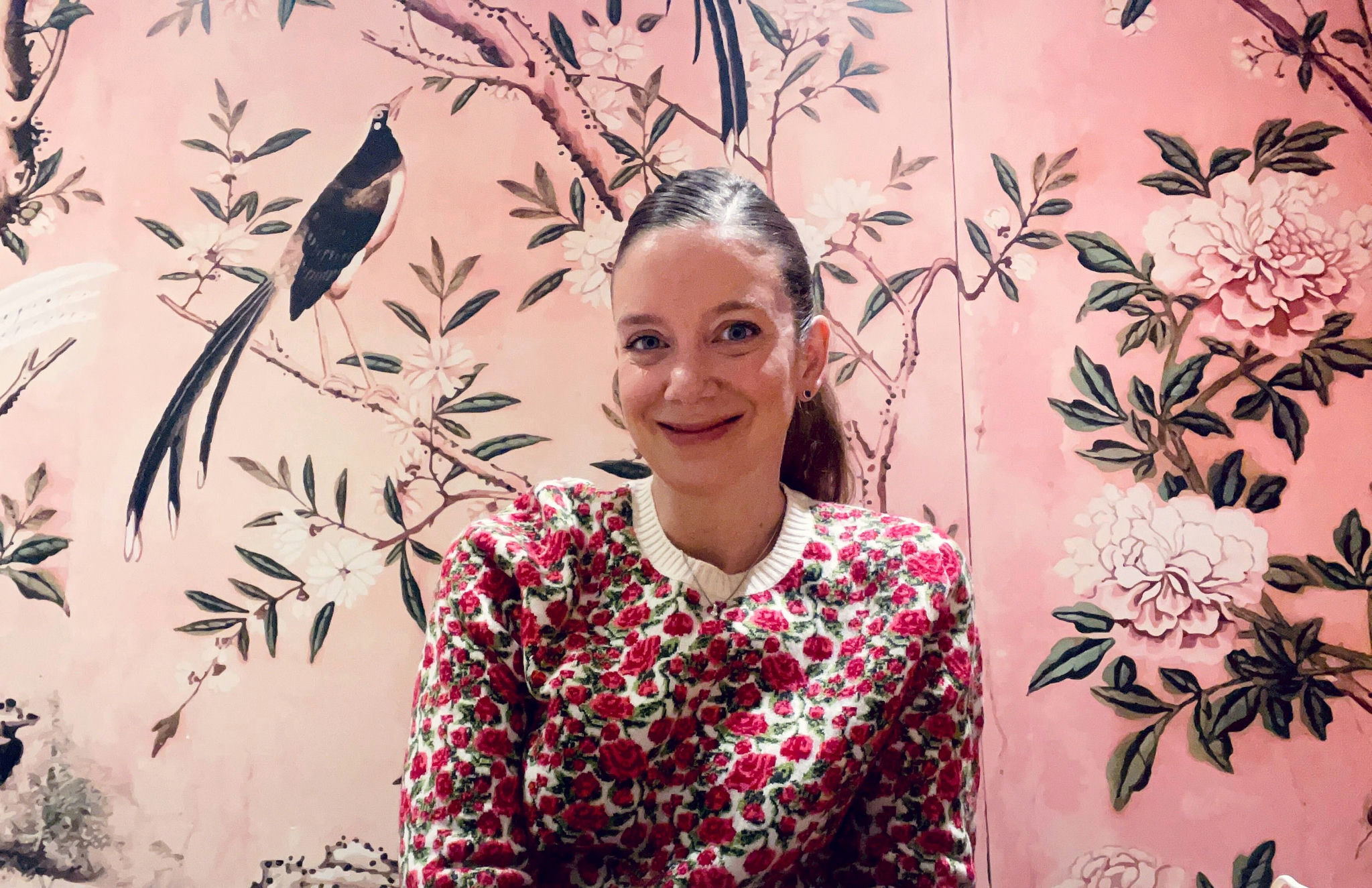 Laura Joudrie, Briar's founder, at her desk in her home office, with chinoiserie wallpaper, smiling.
